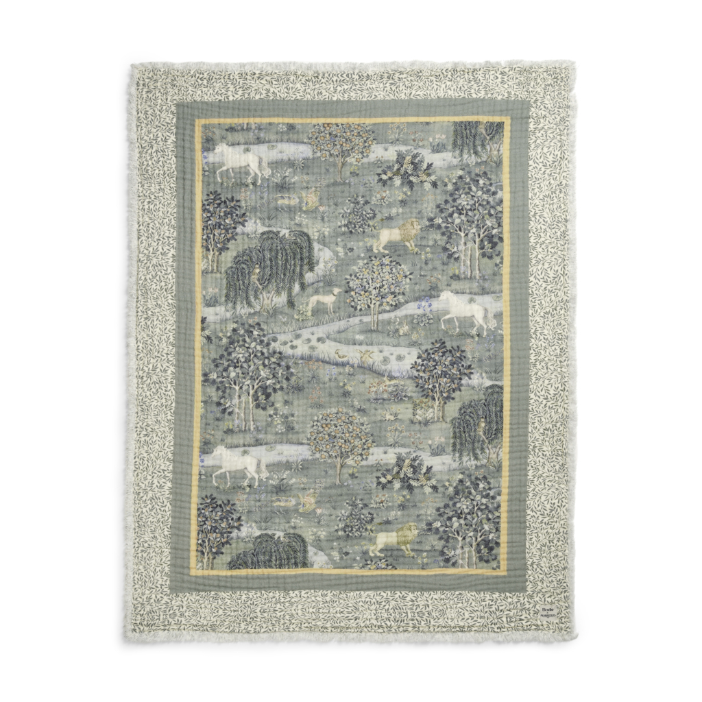 Blanket with embroidered leaves on the border and a magical natural landscape featuring tigers, dogs and horses with a river running through it.