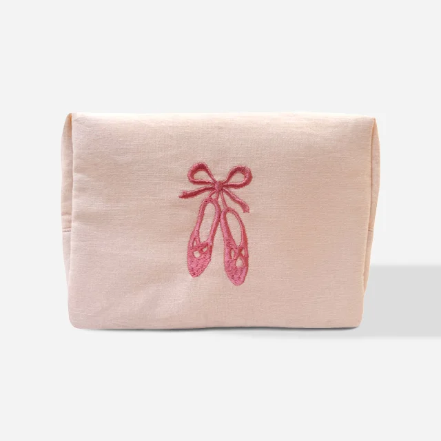 A small light pink bag with ballet shoes tied with a bow embroidered on to the centre